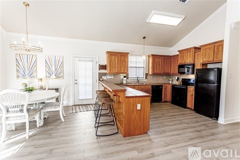 A kitchen with wooden cabinets and a black refrigerator.