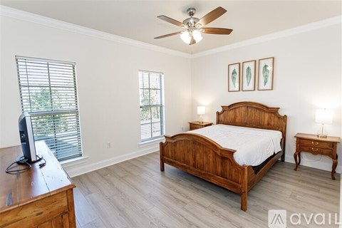 A bedroom with a bed, nightstand, and a television on a wooden dresser.