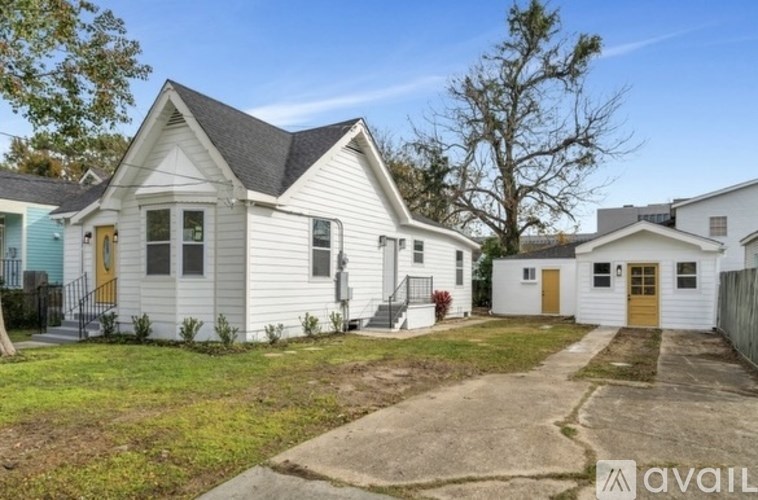 A white house with a brown door is for sale.