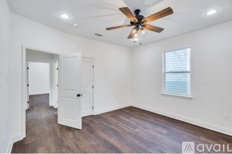 A room with a ceiling fan and wooden floors.