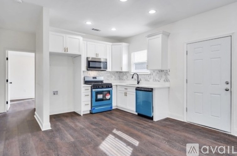 A kitchen with white cabinets and blue appliances.