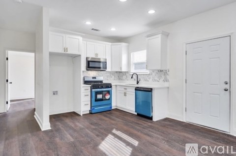 A kitchen with white cabinets and blue appliances.