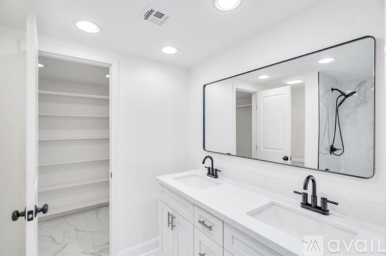 A bathroom with a white sink and a large mirror.