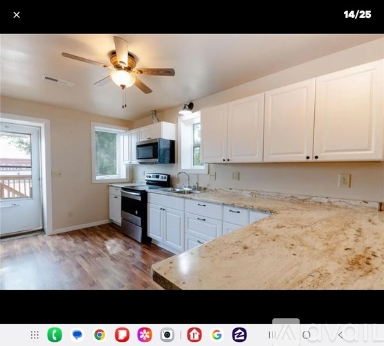 A kitchen with white cabinets and a wooden floor.