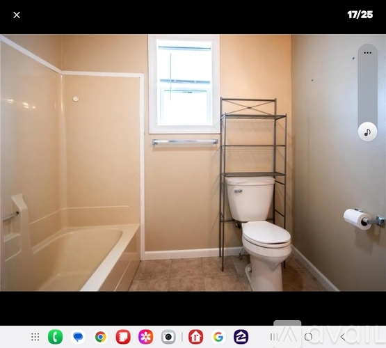 A white toilet sits next to a bathtub in a small bathroom.