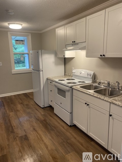 A kitchen with white appliances and cabinets.