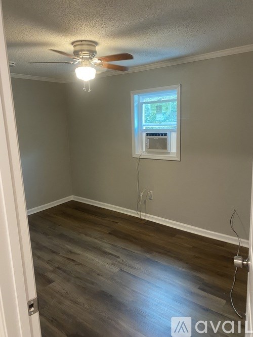 A room with a ceiling fan and a window.