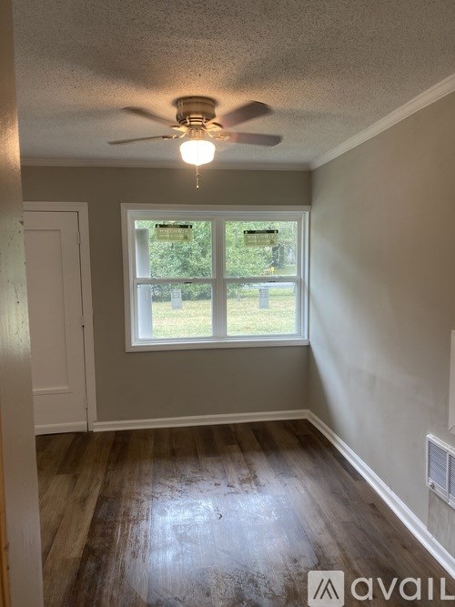A room with a ceiling fan and a window.
