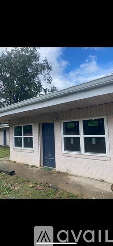 A house with a blue door and windows is for sale.