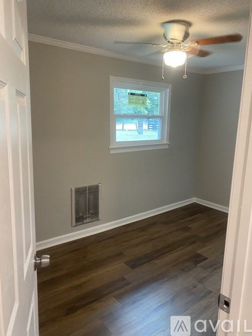 A room with a window and a ceiling fan.