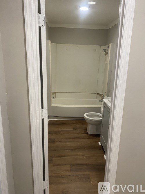 A white bathroom with a toilet and a bathtub.