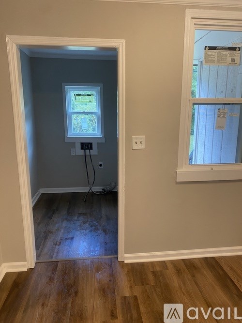 A room with a window and a wall socket.