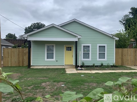 A small house with a yellow door is for sale.