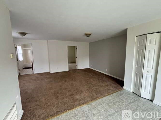 A room with brown carpet and white walls.