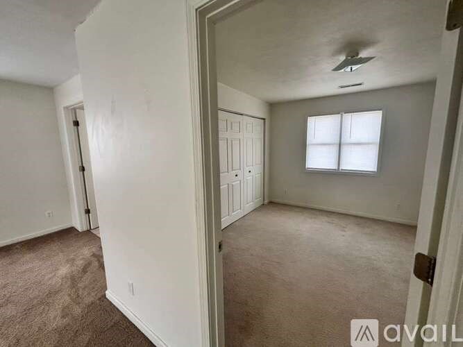 A room with a ceiling fan and a window.