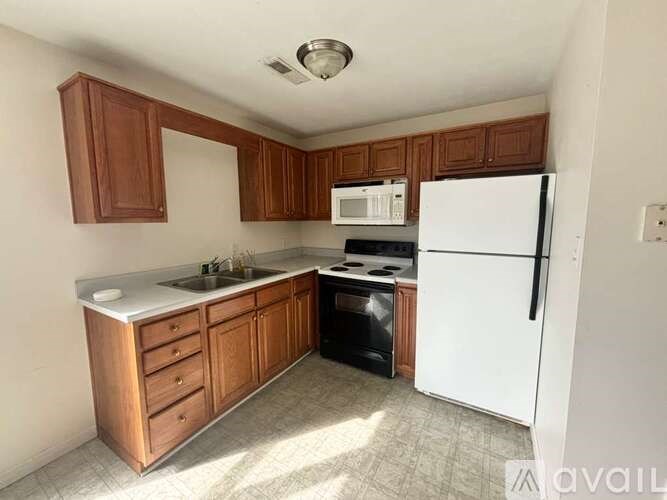 A kitchen with wooden cabinets and a white refrigerator.