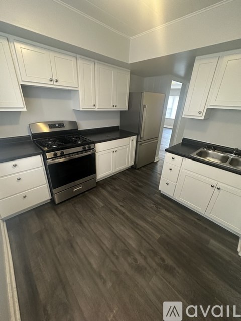 A kitchen with white cabinets and a black stove top.