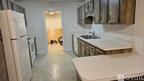 A kitchen with a white refrigerator and wooden cabinets.