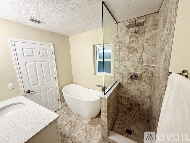 A bathroom with a white tub and a walk-in shower.