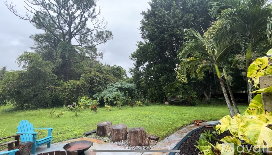A backyard with a fire pit and a blue chair.