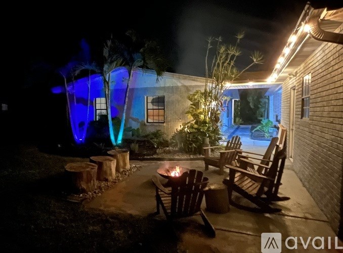 A cozy outdoor seating area with a fire pit and chairs.