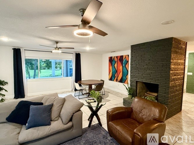 A living room with a couch, chair, and a fireplace.