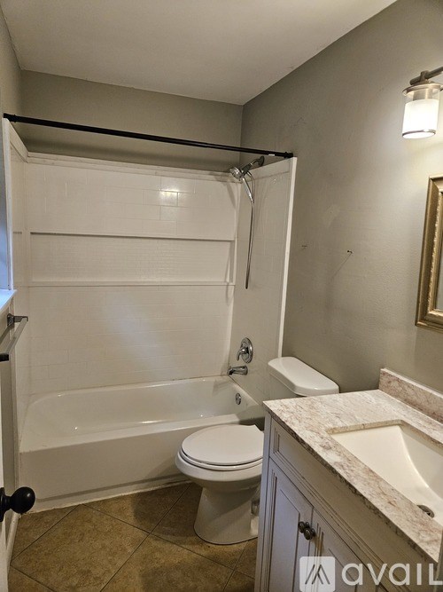A bathroom with a toilet, sink, and bathtub.