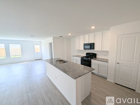 A kitchen with white cabinets and a granite countertop is available for rent.