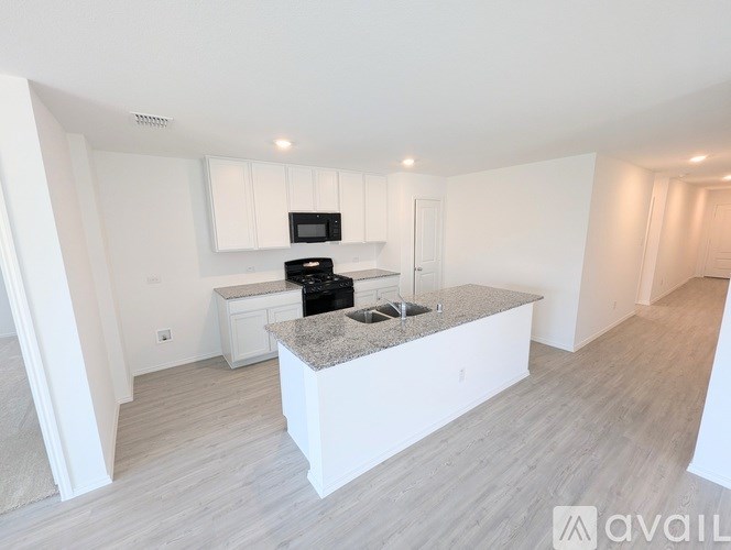 A modern kitchen with a granite countertop and stainless steel appliances.