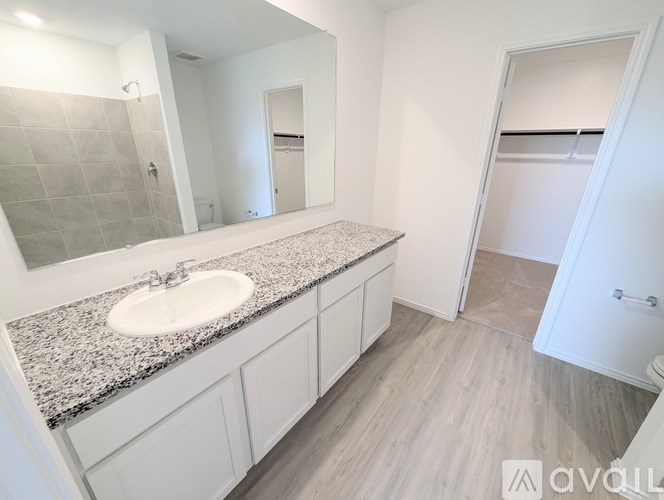 A bathroom with a granite countertop and white sink.