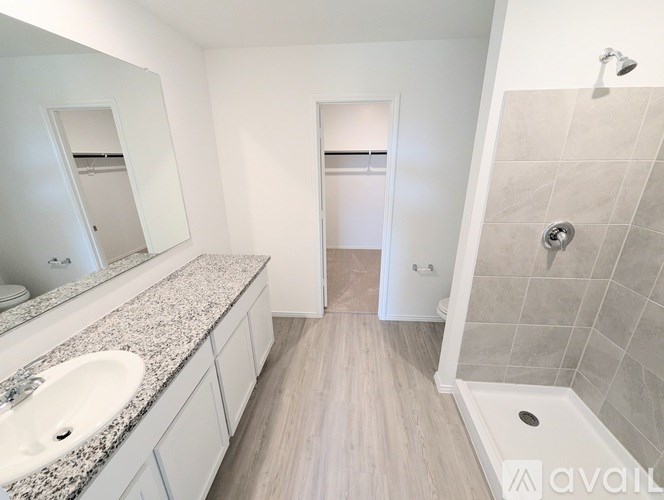 A bathroom with a sink, mirror, and shower.