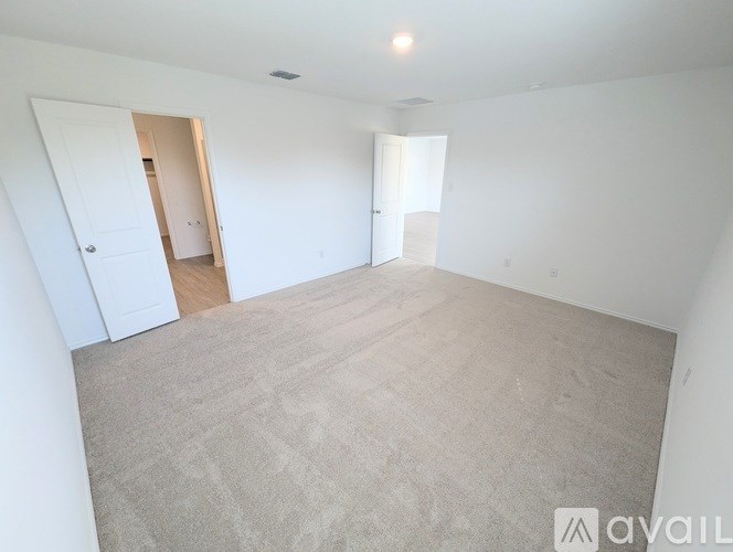A large, empty room with carpeted floor and white walls.