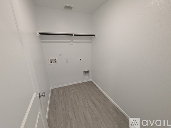 A white hallway with a door on the left and a small closet on the right.