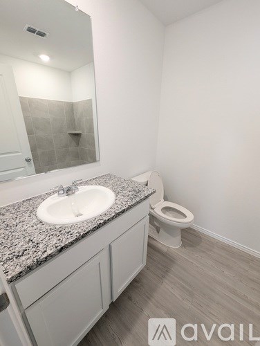 A bathroom with granite countertops and a white sink.