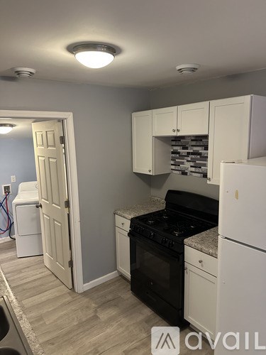 A kitchen with a black stove top oven and white cabinets.