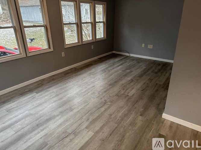A room with grey walls and wooden flooring is available.