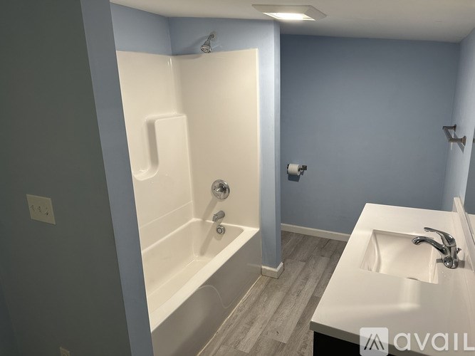 A bathroom with a white bathtub and a white sink.