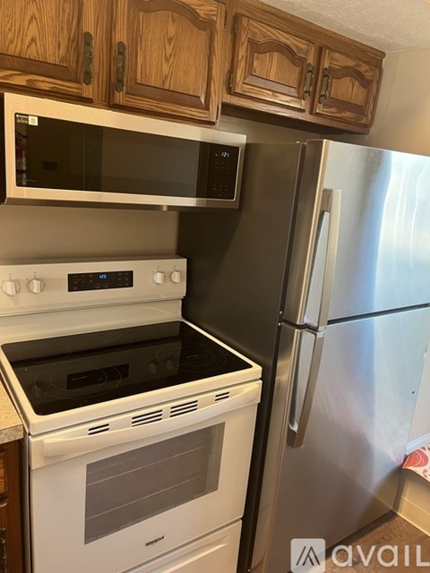 A kitchen with a white stove and a silver refrigerator.