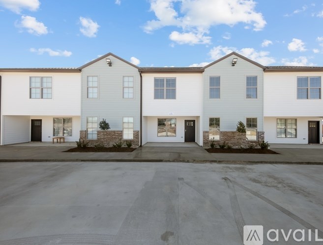 A row of modern townhouses with a clear blue sky above them.