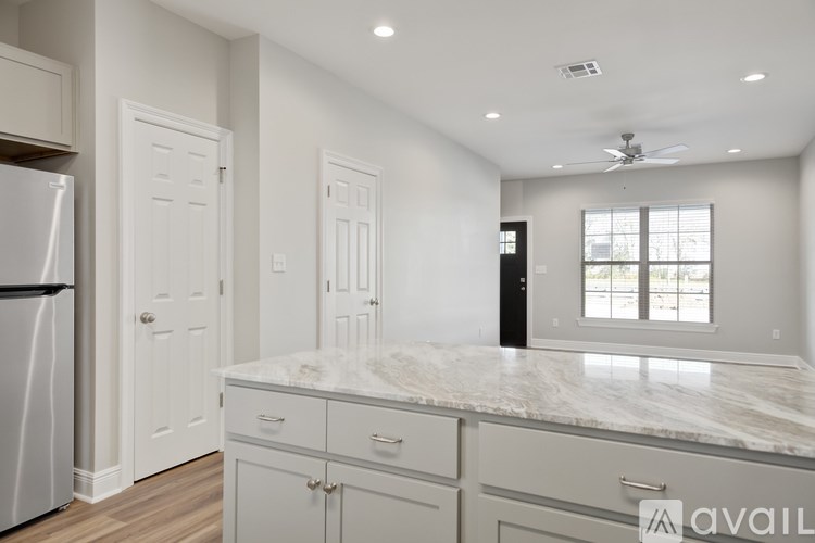 A kitchen with white cabinets and a marble countertop.