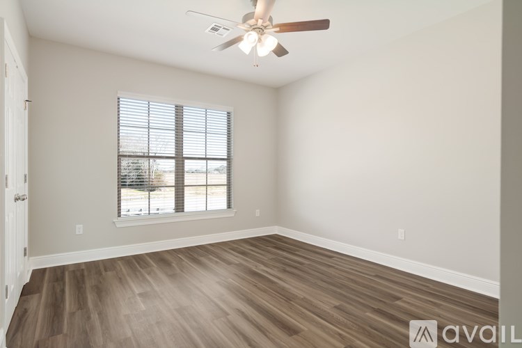 A room with a ceiling fan and wooden flooring.