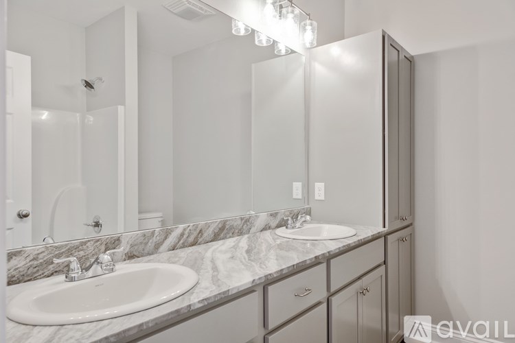 A bathroom with a marble countertop and a large mirror.