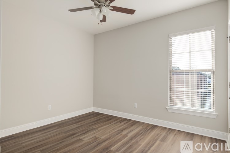 A room with a ceiling fan and a window with blinds.