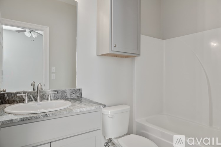 A bathroom with a toilet, sink, and mirror.