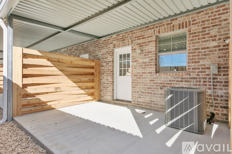 A garage with a wooden door and a brick wall.