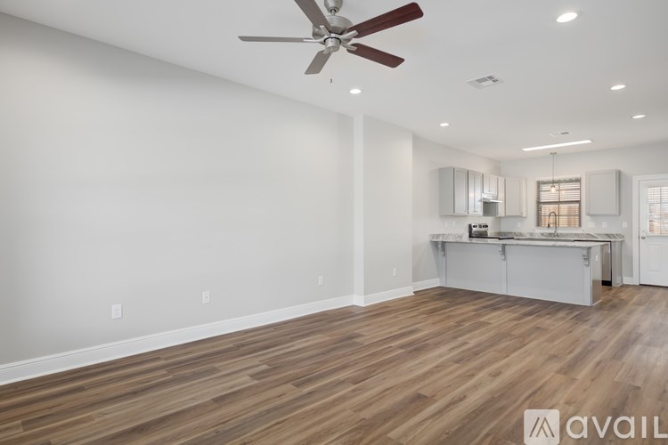 A room with a ceiling fan and wooden flooring.