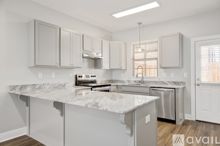 A kitchen with white cabinets and a marble countertop.