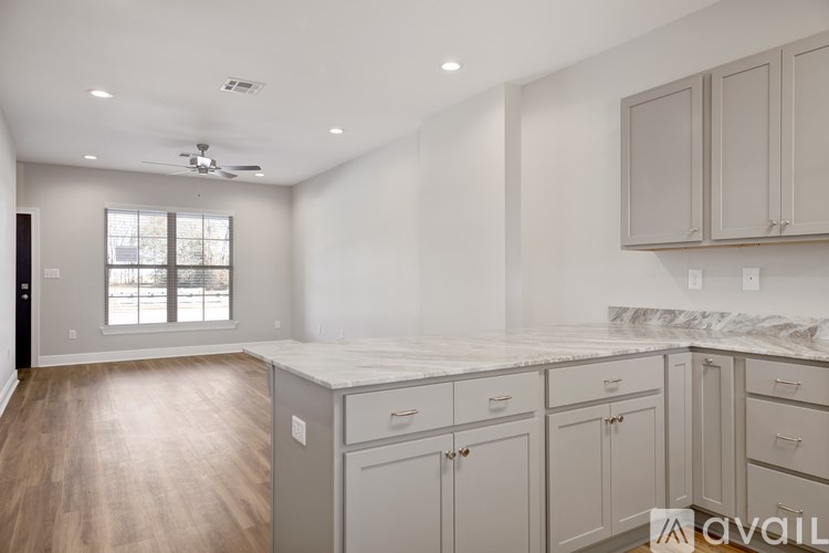 A kitchen with a marble countertop and wooden flooring.