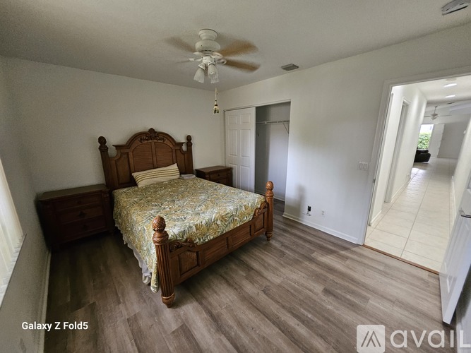 A bedroom with a bed, dresser, and ceiling fan.
