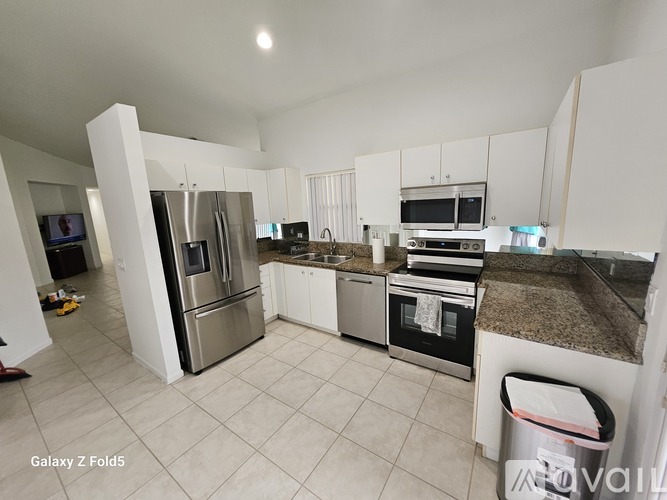 A kitchen with white cabinets and a granite countertop.